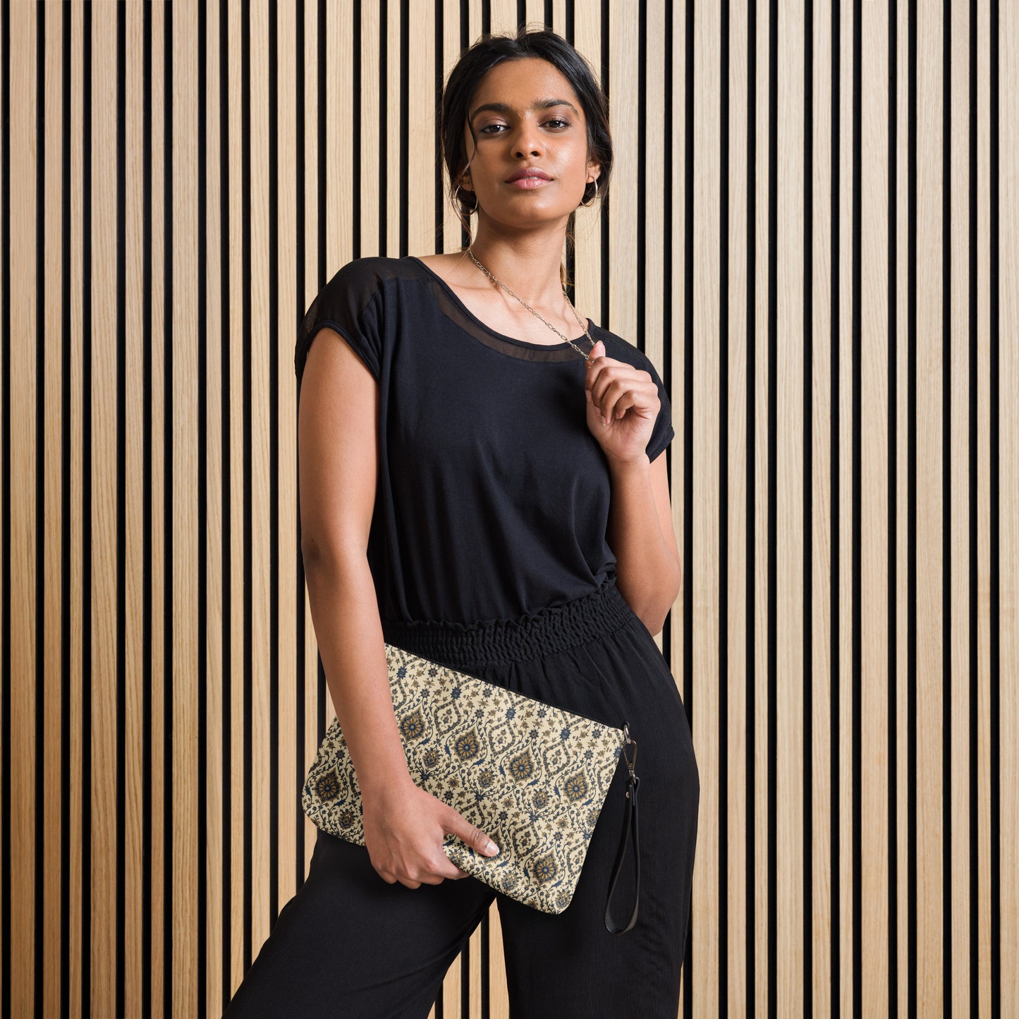 Woman holding a clutch against a striped wall