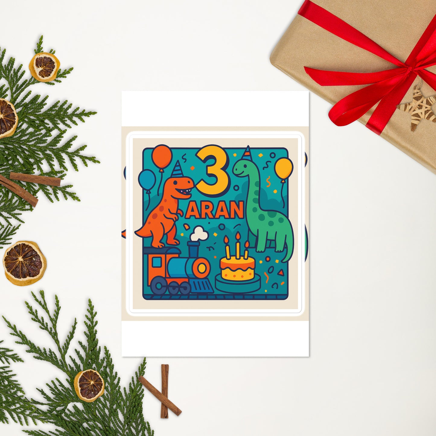 Children's birthday card with dinosaurs, number 3, and name 'Aran' on a white background with Christmas decorations.