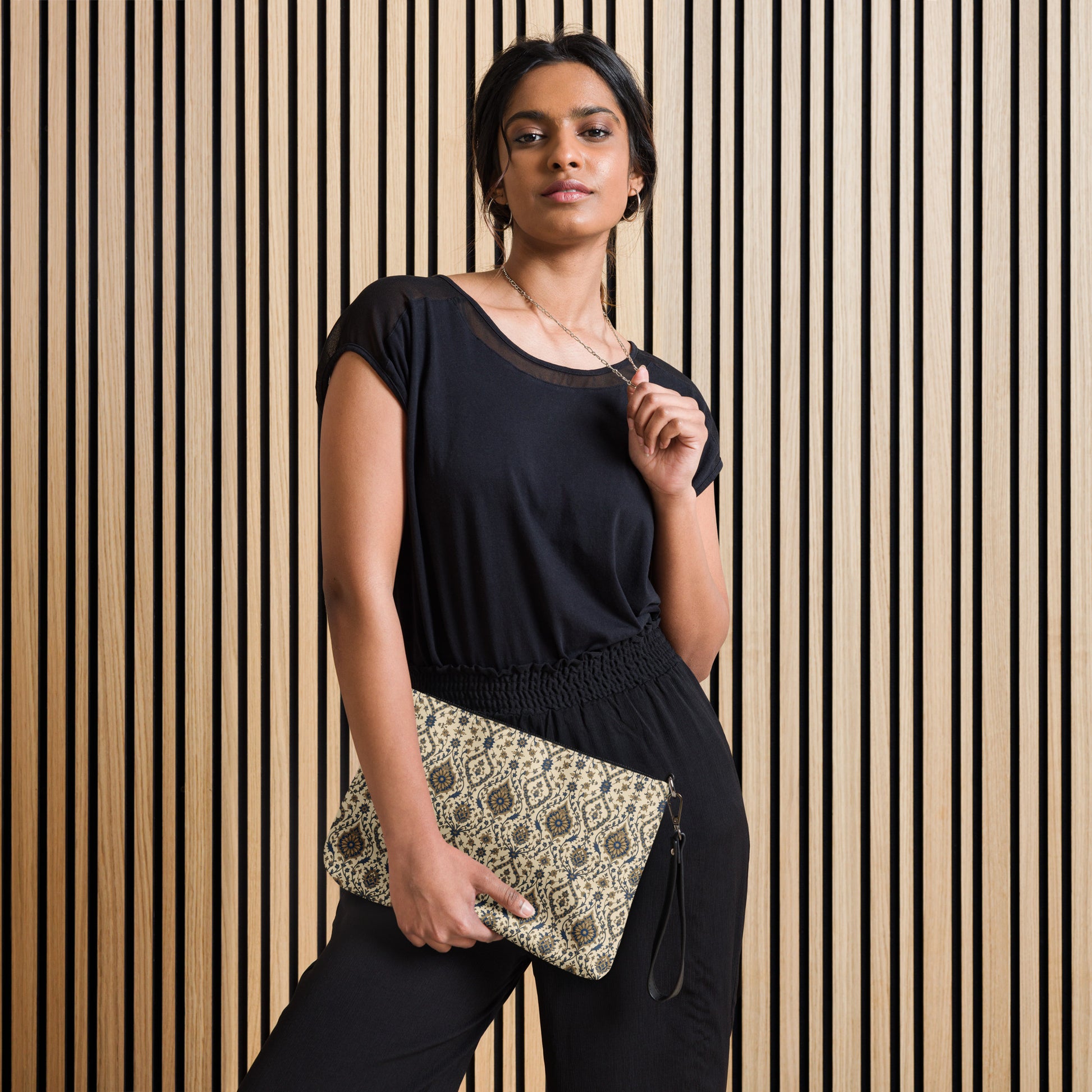 Woman holding a clutch against a striped wall