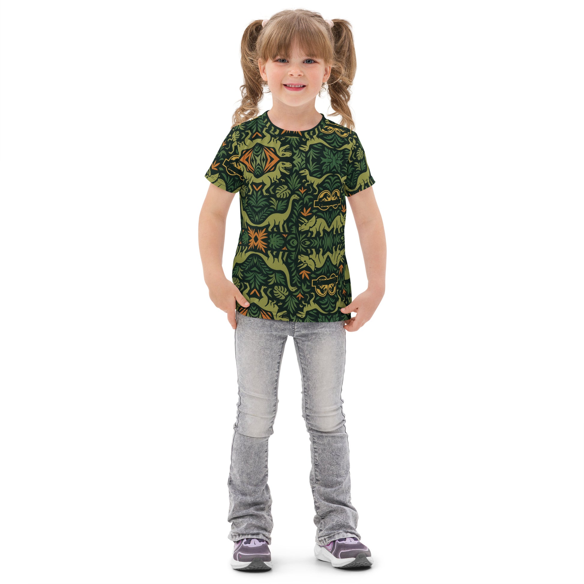 Young girl wearing a green t-shirt with dinosaur pattern and gray pants on a white background