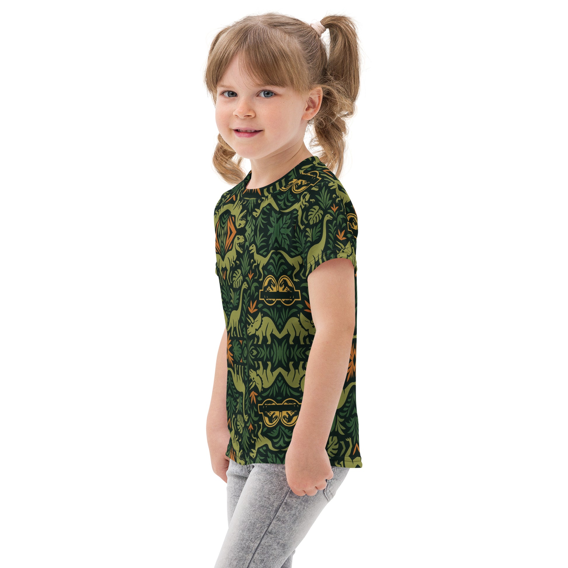 Child wearing a green t-shirt with dinosaur pattern on a white background