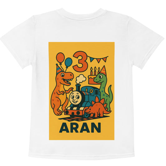White t-shirt with a colorful graphic of dinosaurs and a train on a yellow background, featuring the name 'Aran' and the number '3'.