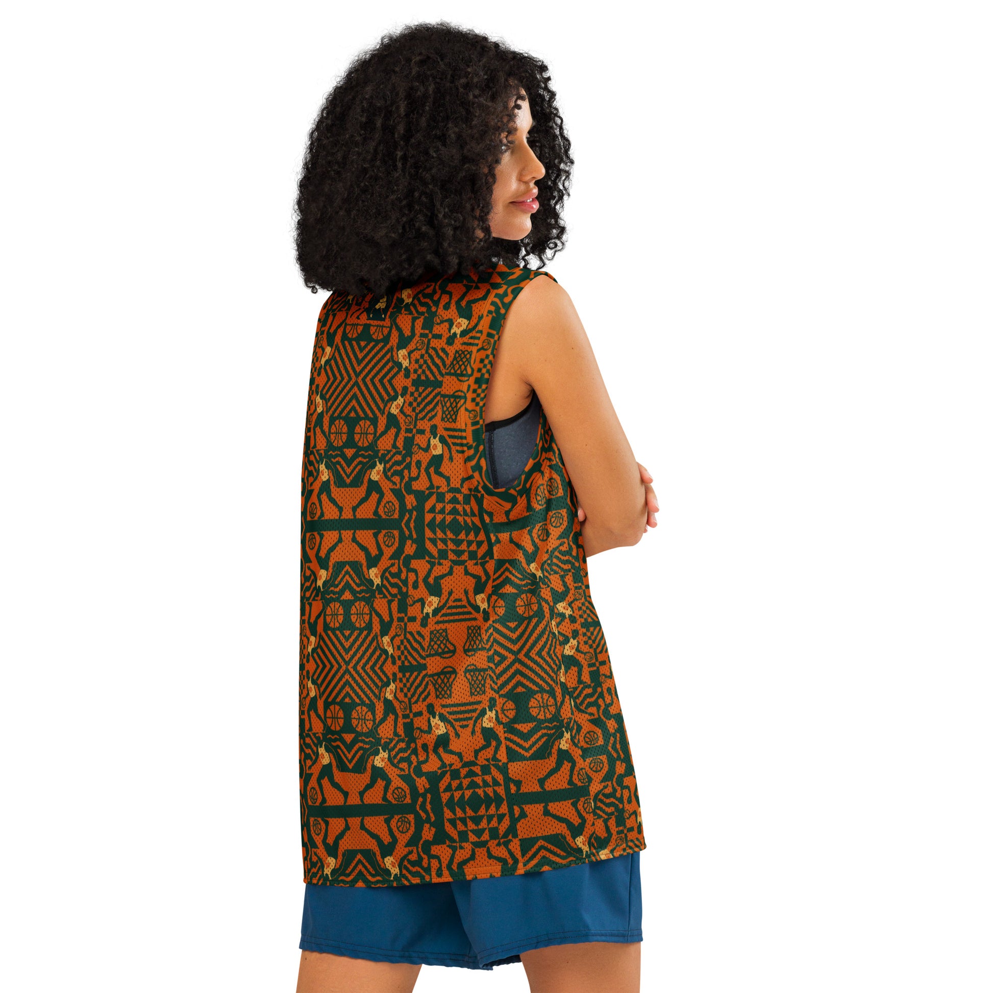 Woman wearing a sleeveless patterned top and blue shorts on a white background