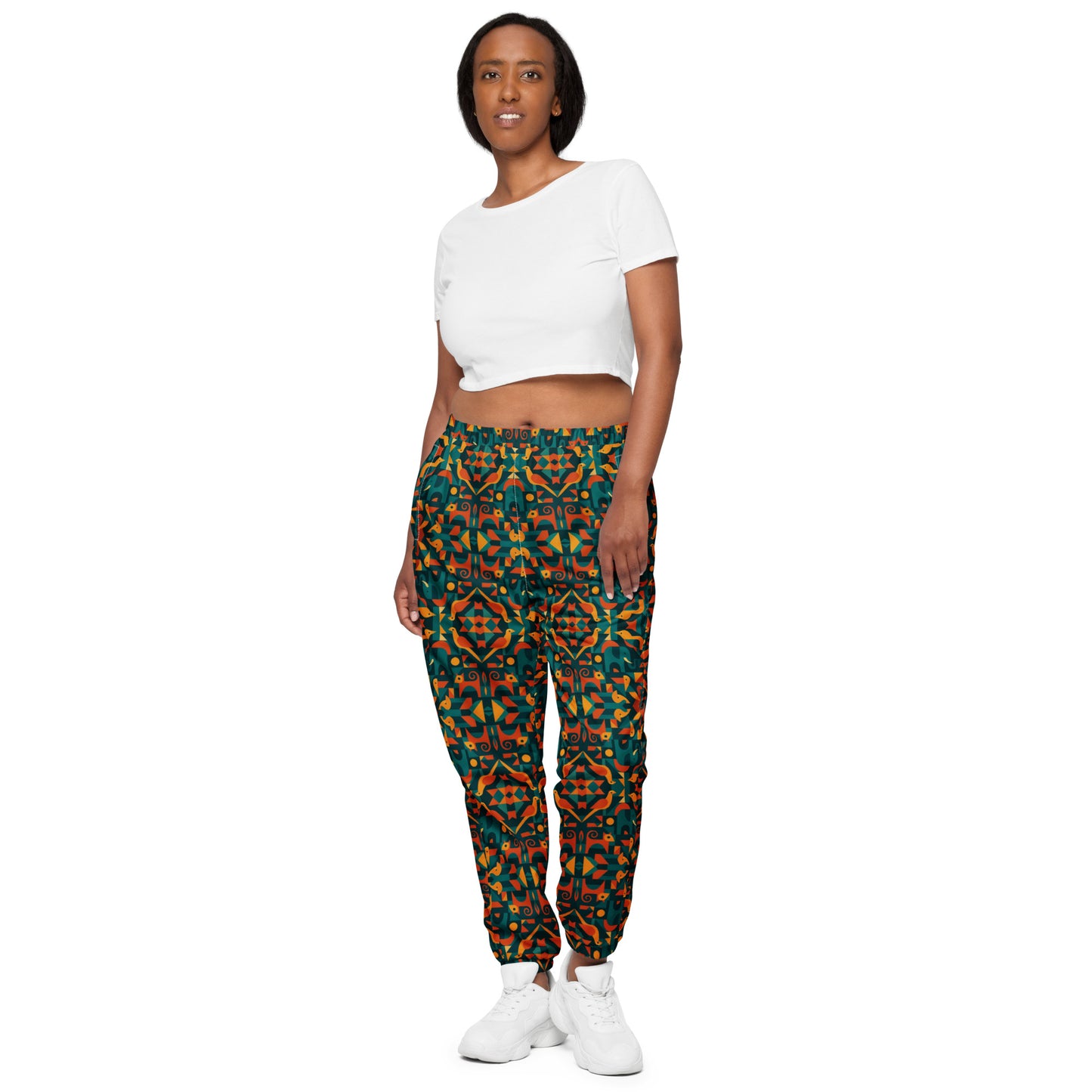 Woman wearing a white crop top and patterned pants on a white background