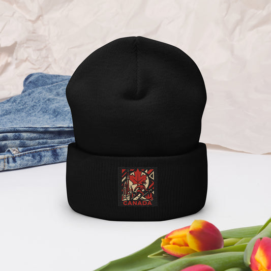Black beanie with a Canada-themed patch on a white surface with jeans and tulips.
