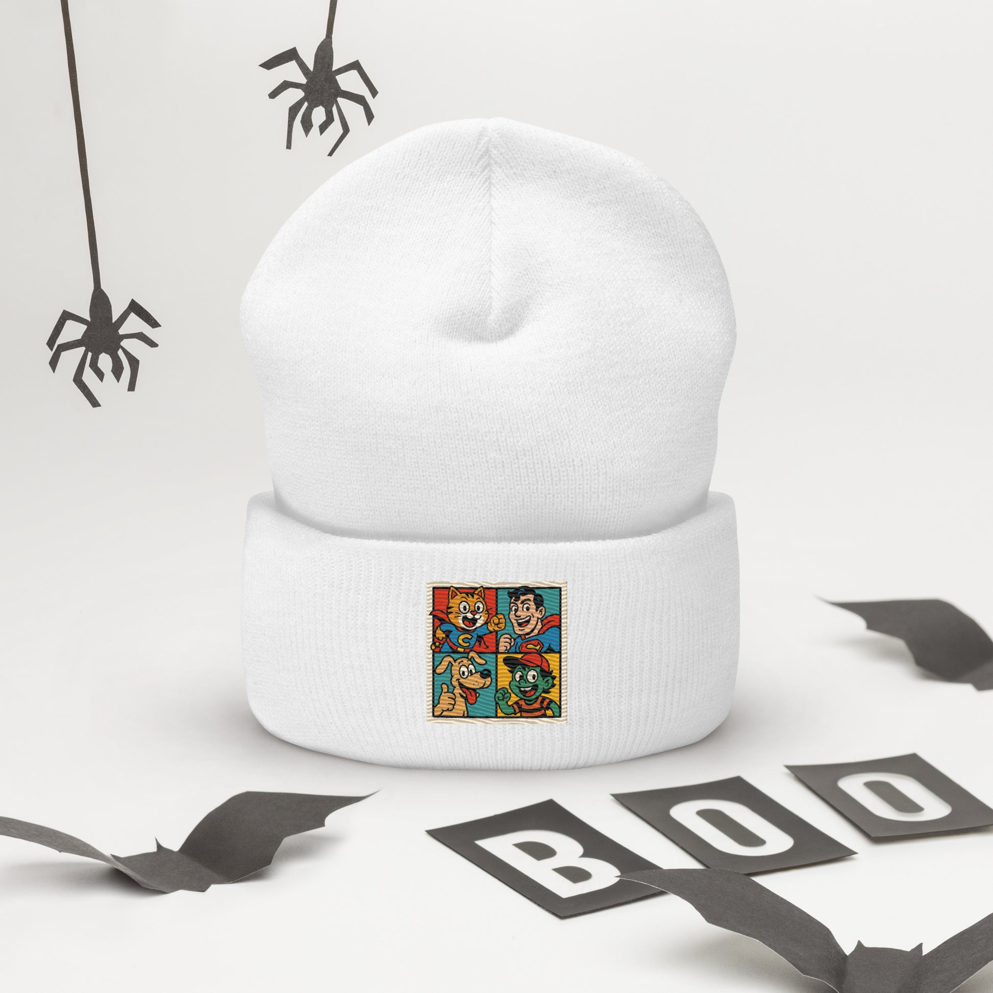 White beanie with a colorful graphic design on a white background with Halloween decorations.