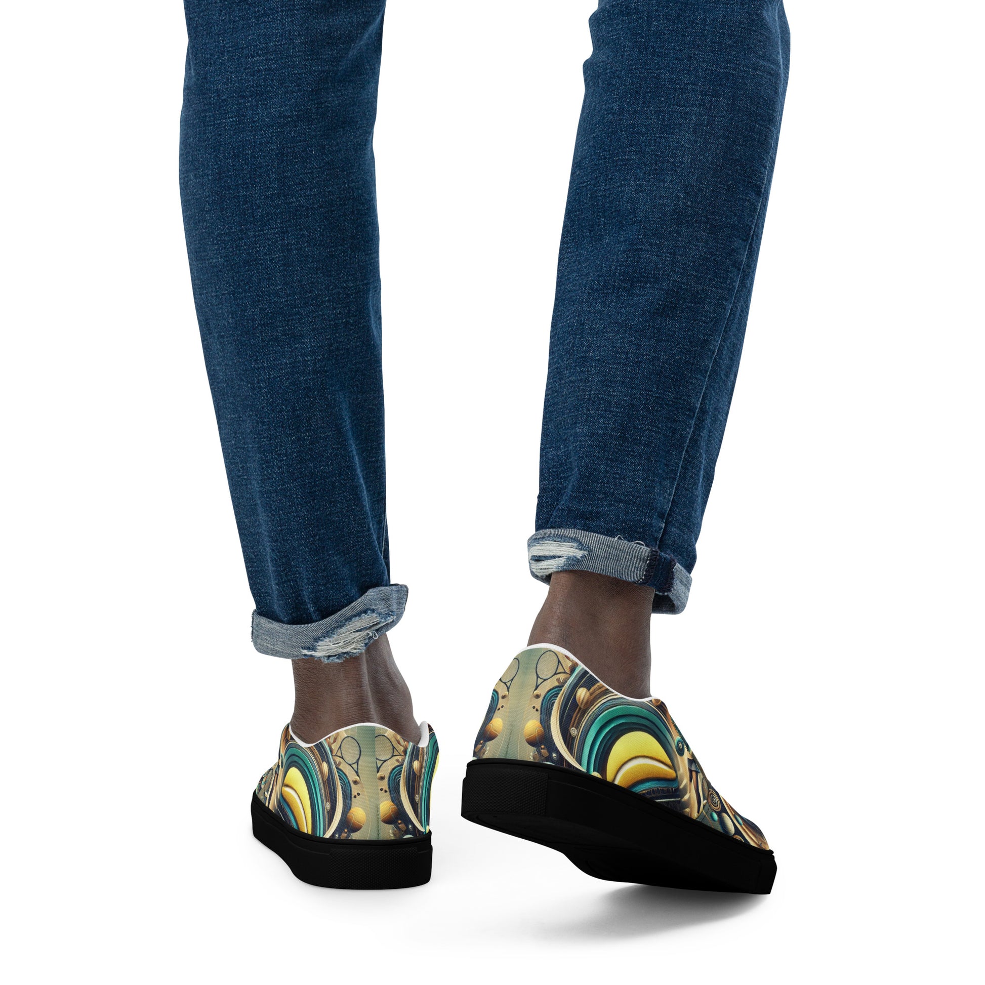 Person wearing colorful slip-on shoes with a pattern, paired with blue jeans on a white background.