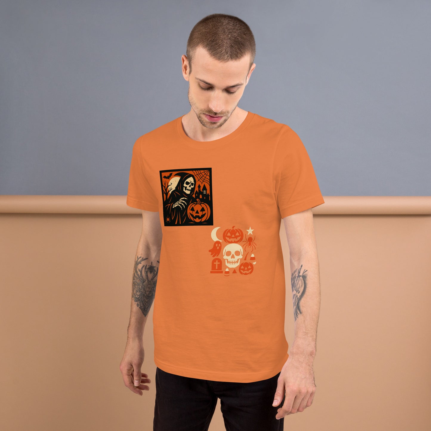 Man wearing an orange t-shirt with Halloween-themed graphics against a plain background
