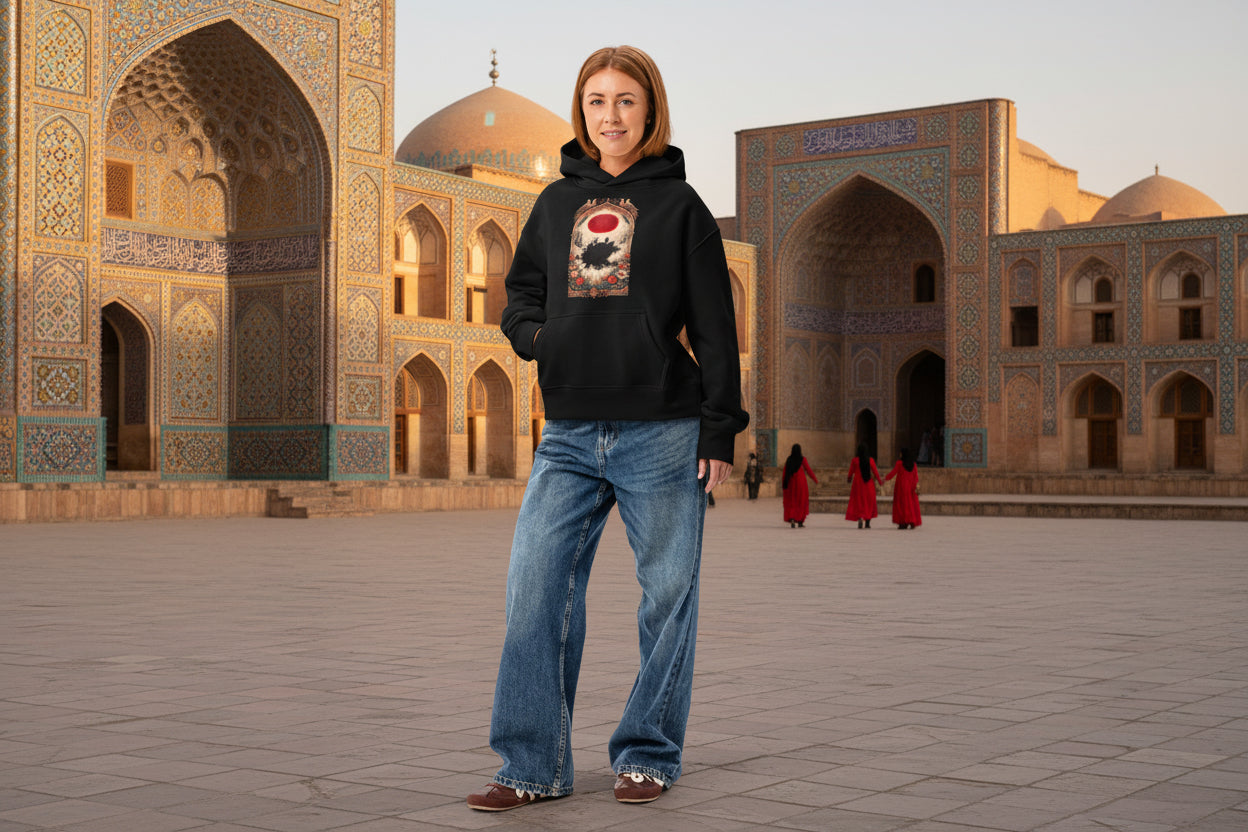 Person wearing a black hoodie with a graphic design and blue jeans on a white background