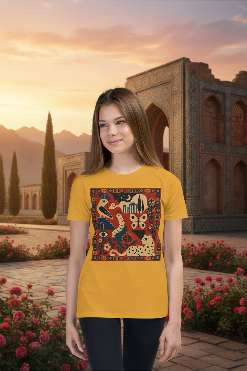 A young woman modeling a mustard yellow t-shirt with a colorful, detailed graphic print on the front depicting stylized animals and patterns, set against a plain white background.