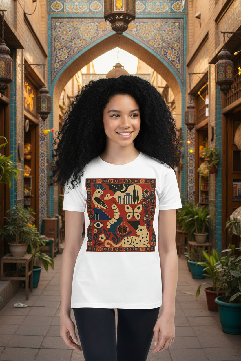 A young woman modeling a white short-sleeve crewneck t-shirt with a large, colorful, vintage-style graphic print on the front featuring snakes, butterflies, and a cat in warm tones.